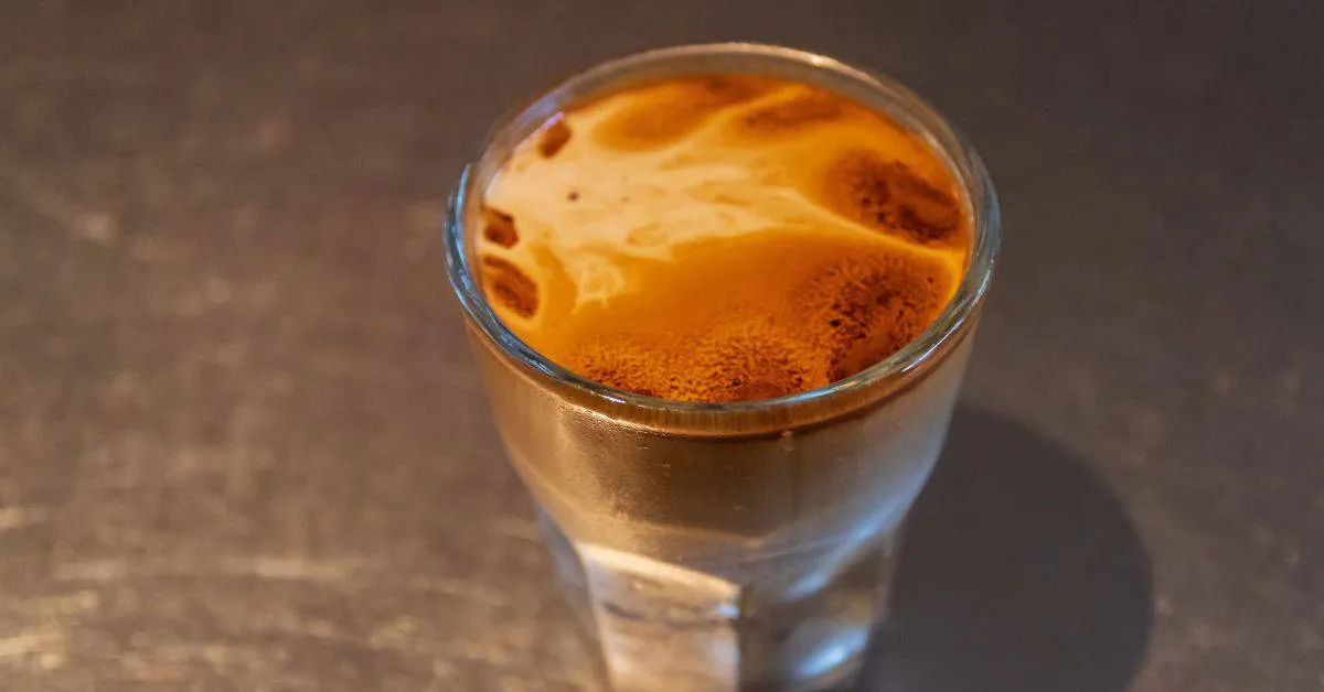 A freshly made Breve coffee on a steel table.