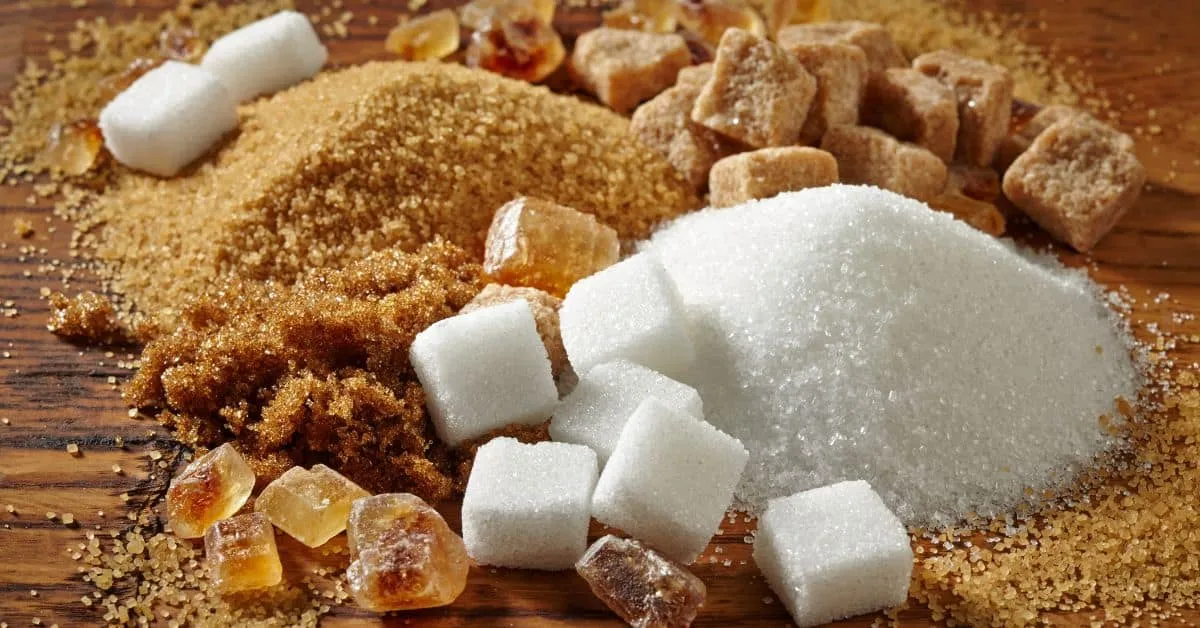 Different kinds of sugar on a wooden table.
