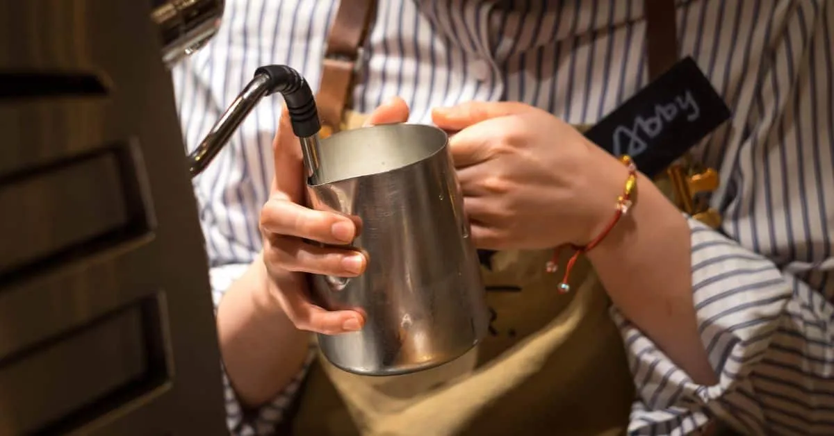 Starbucks barista steaming some Oatly milk