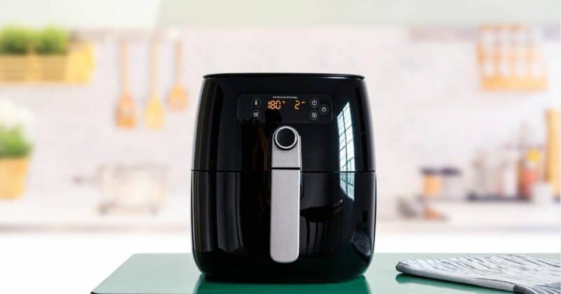 A black air fryer on a kitchen counter.
